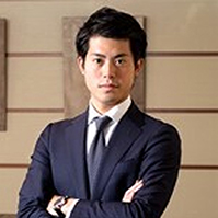 McKinsey alum Shogo Okada in a suit, standing with his arms folded