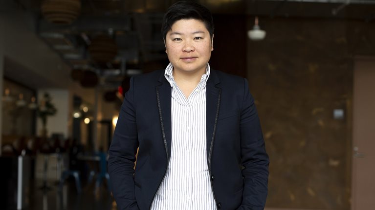 A photo of Jen Wong wearing a striped shirt and dark blazer