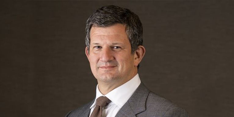 Headshot of Steve Hasker with a dark background