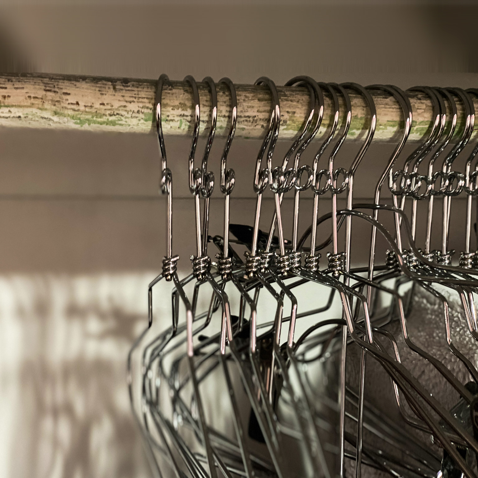 Empty metal clothing hangers in closet - stock photo