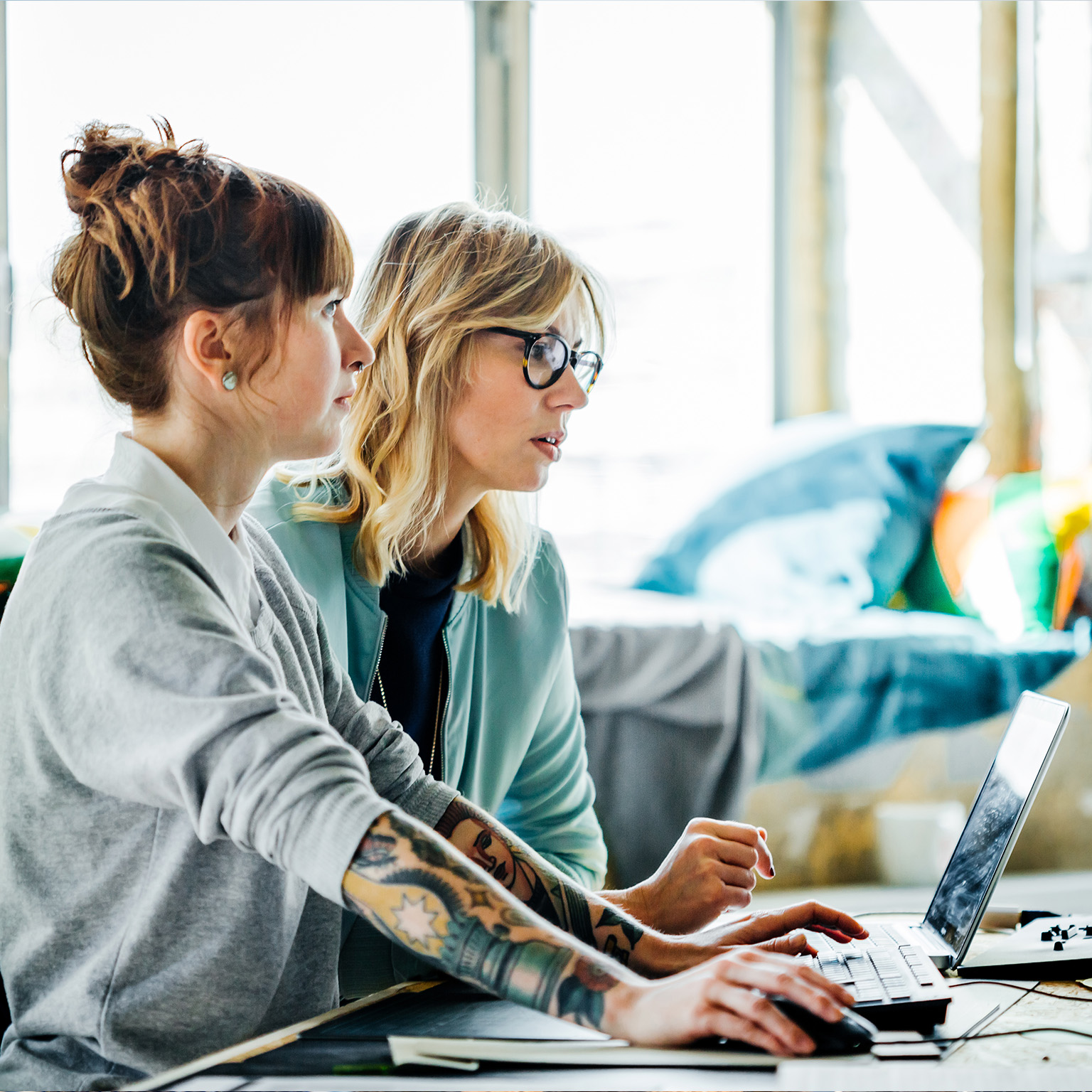 Two businesswomen working on a computer - stock photo