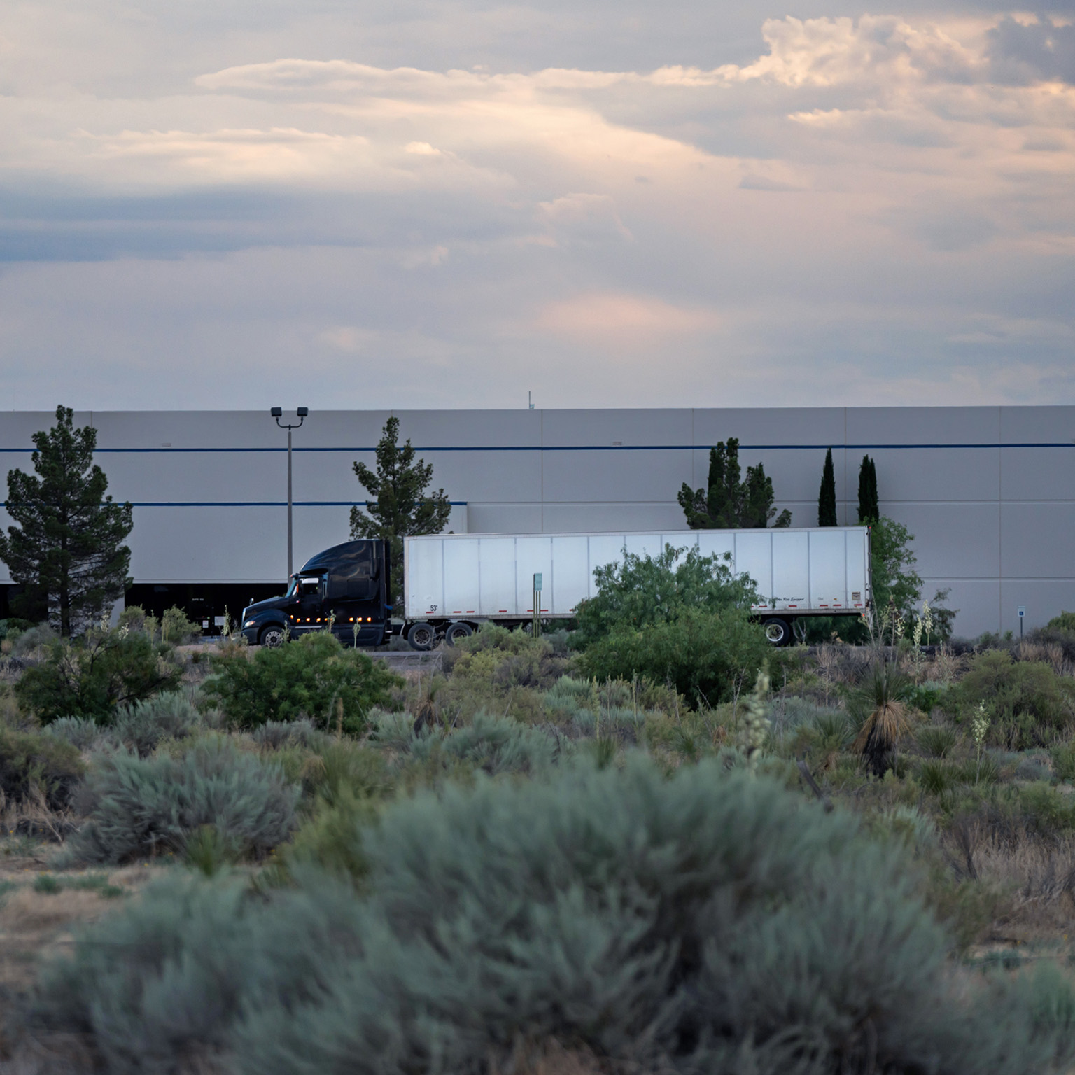 Semi truck on highway in front of a building near the US/Mexico border