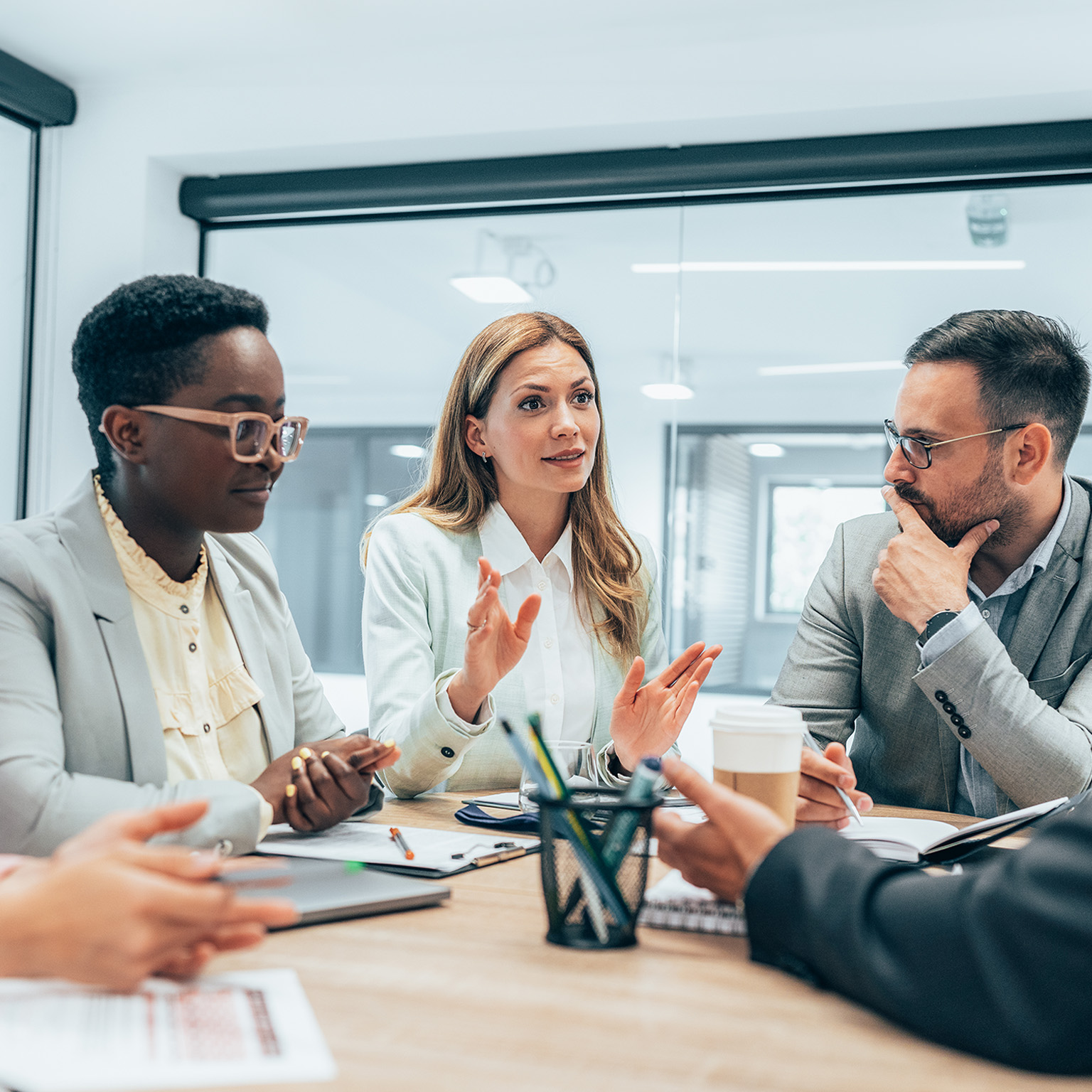 Modern business team smiling and talking in board room discussing new ideas at the office.