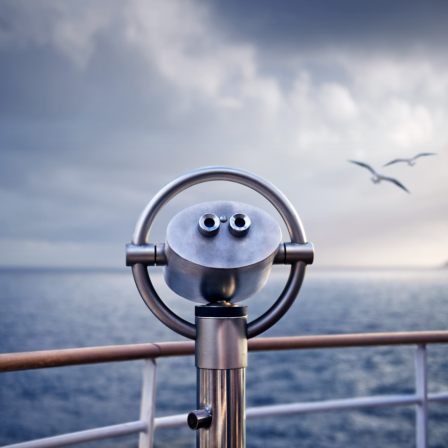 Telescope on a ship with two birds flying over the water in the background