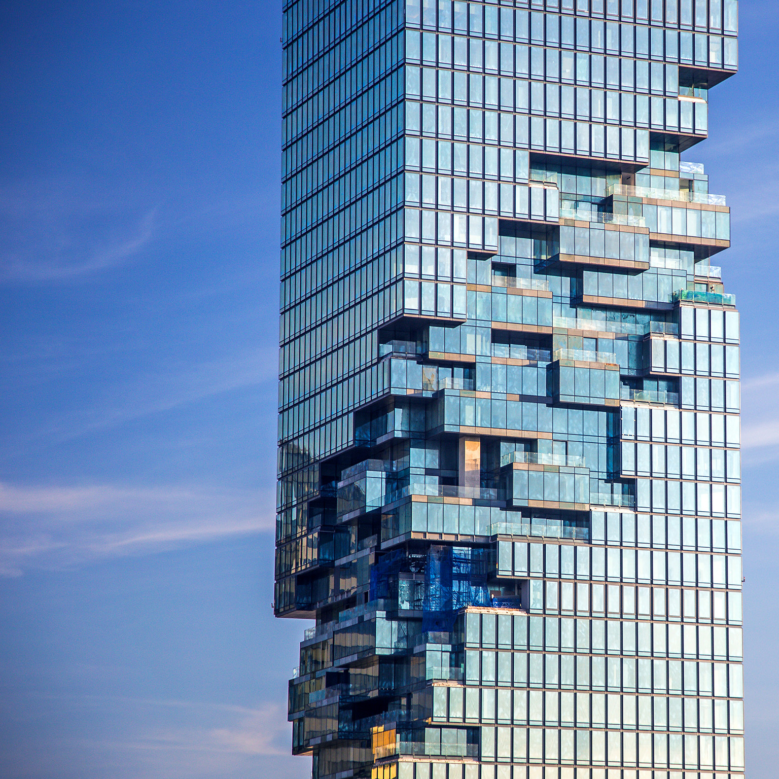 Tall building with special design showing internal glass structure in the center.