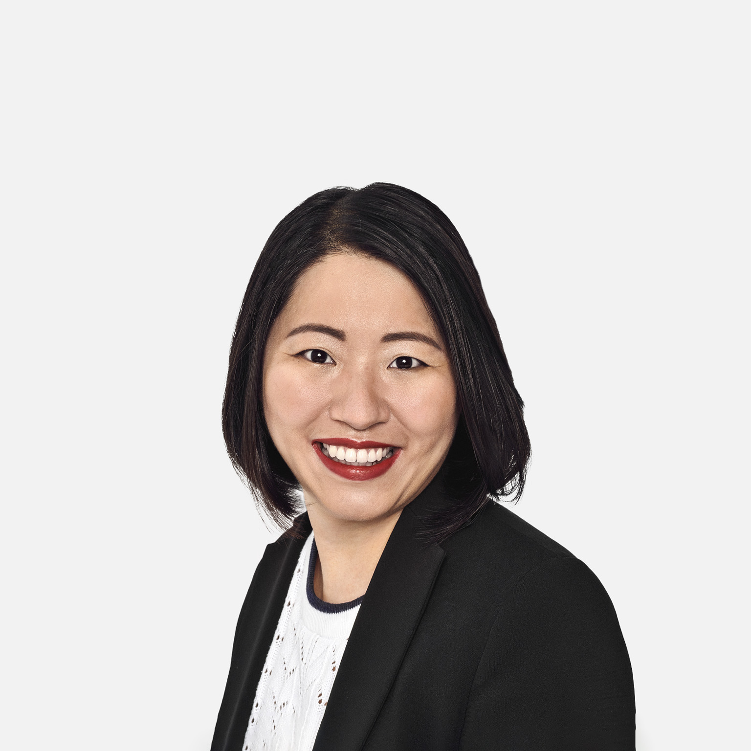 Portrait of Marjorie Lao with a bright smile and wearing a suit jacket over a fine knit top.