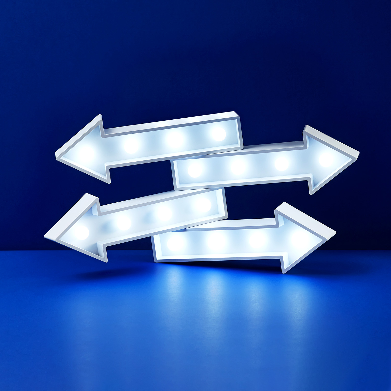 Image of four stacked lit up arrows pointing in different directions.