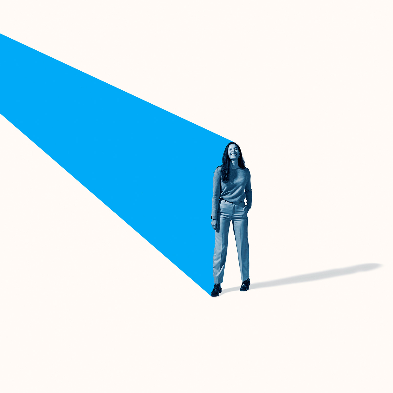 Full length image of a smiling woman standing with an angled turquoise beam 