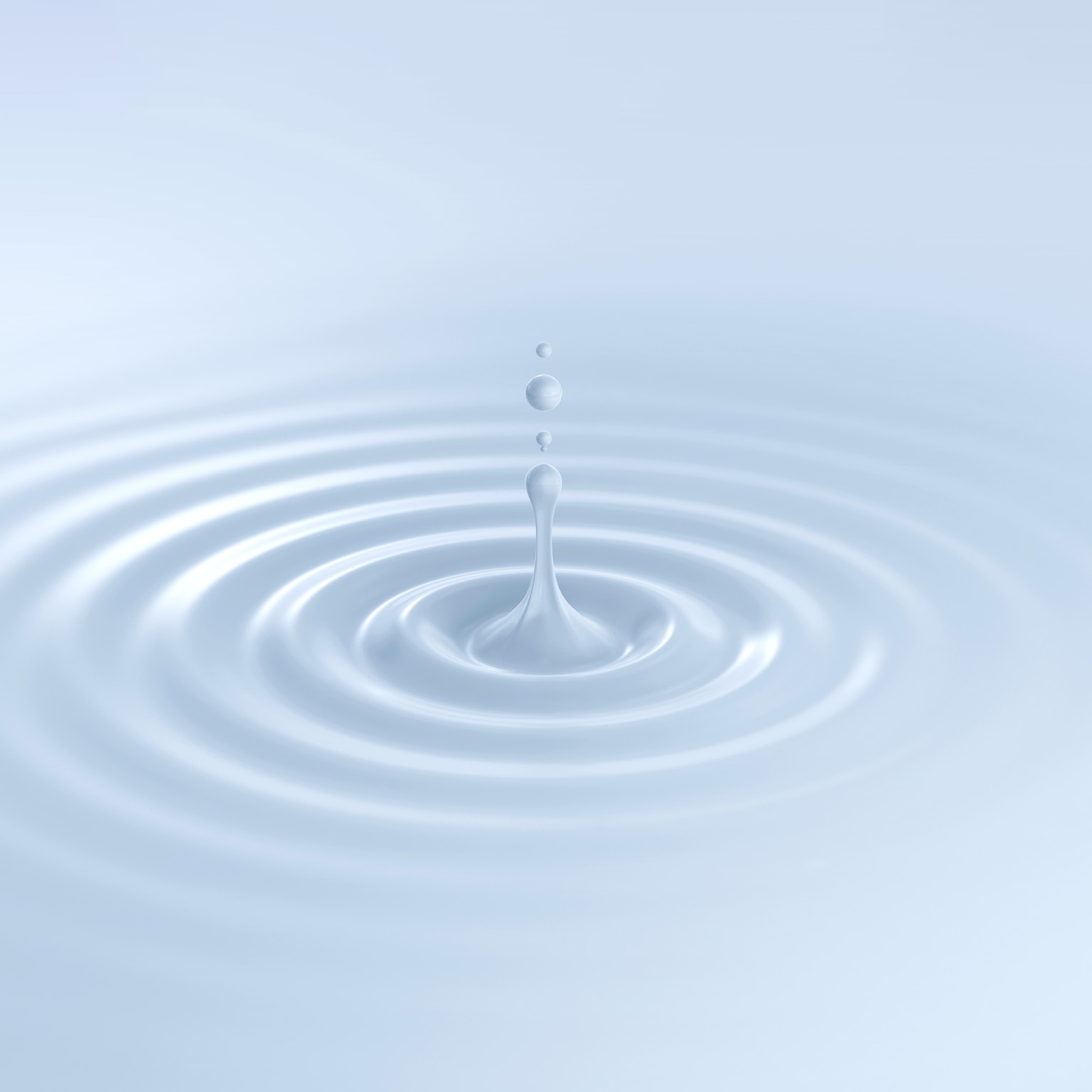 A single droplet of milky white liquid splashes up from a rippling surface. Gentle concentric ripples spread outward across the white background.