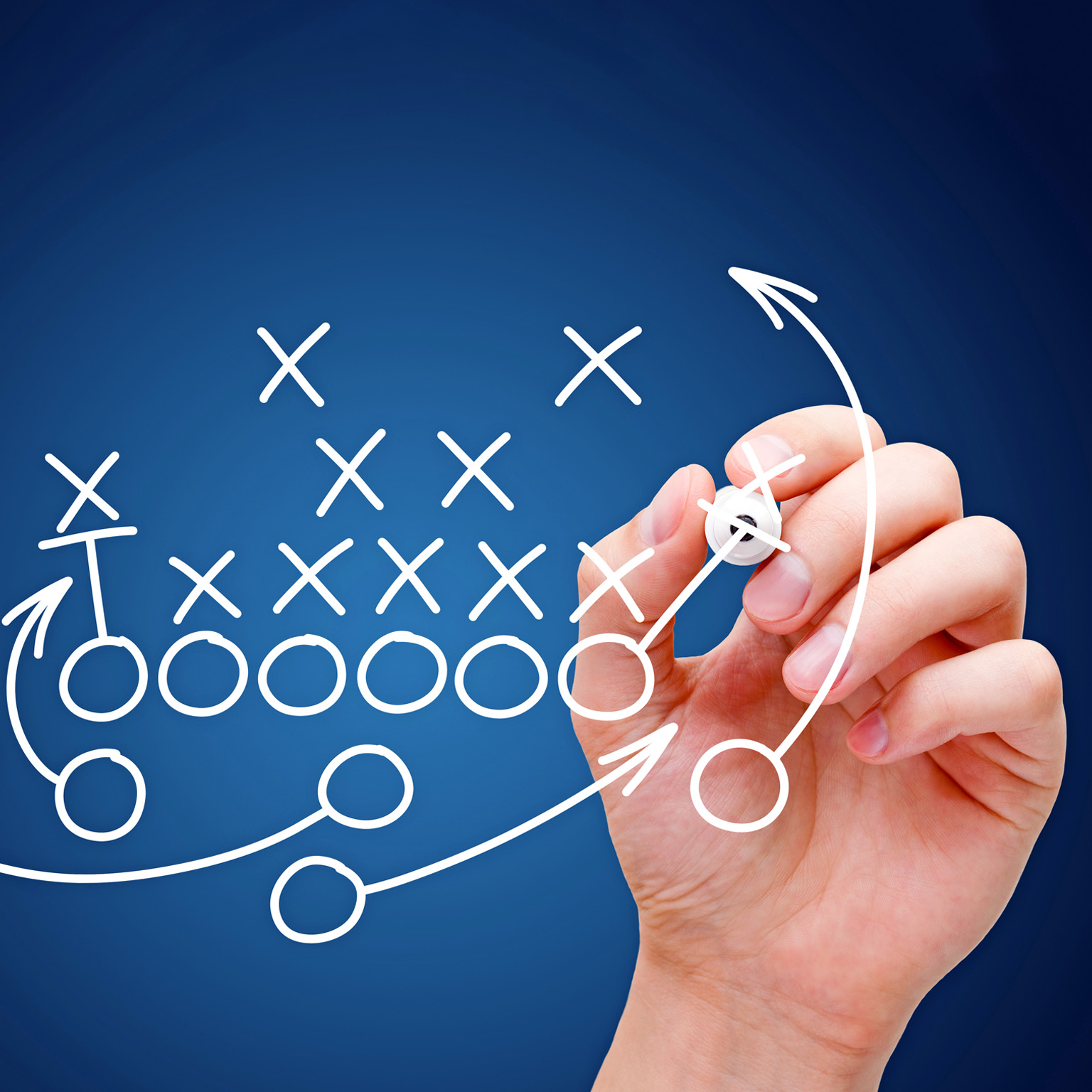 A football play diagram is being sketched by a hand, featuring Xs and Os to represent players and arrows indicating their movements.