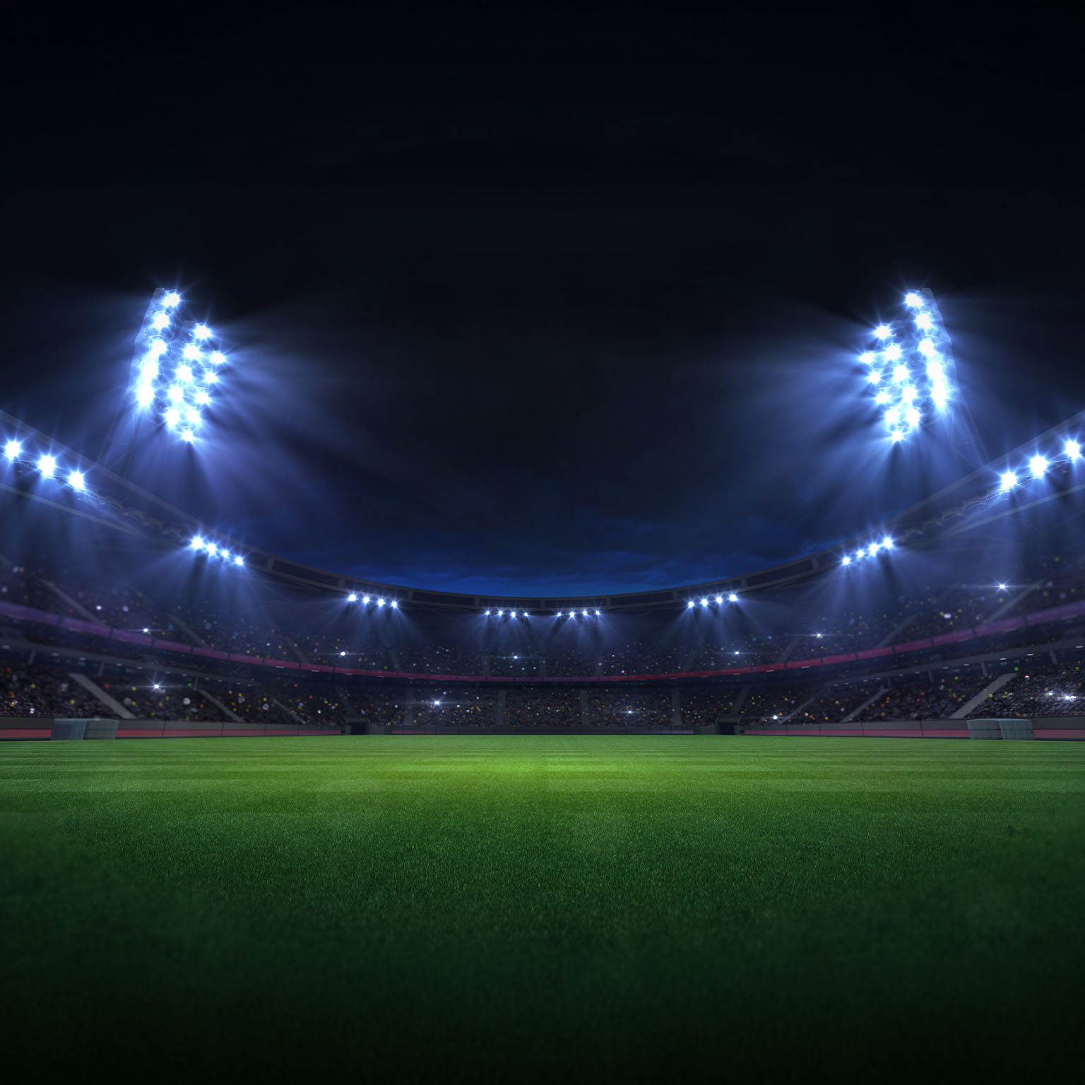 Universal grass stadium illuminated by spotlights and empty green grass playground