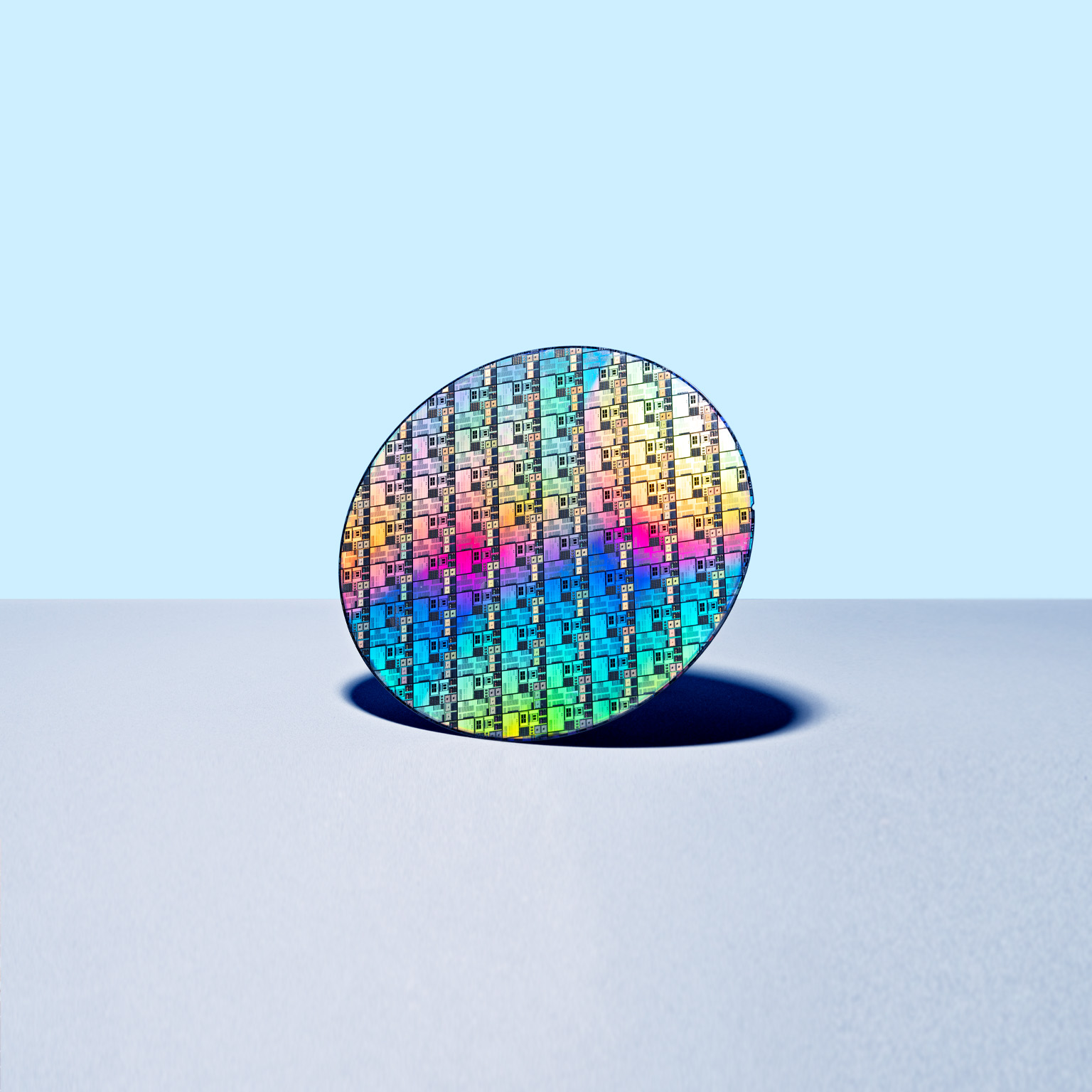 Colorful Iridescent Silicon Computer Wafer on Blue Colored Background.