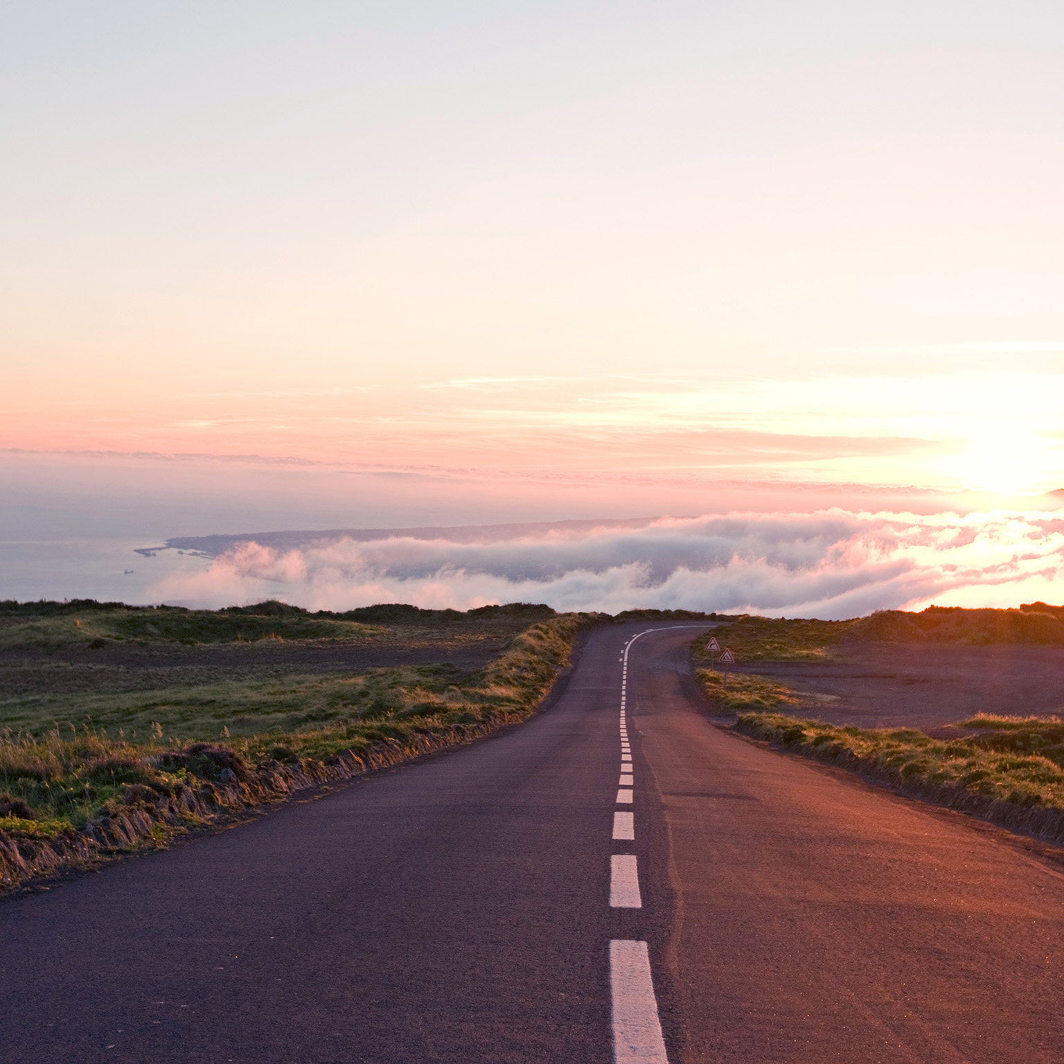 A long country road trailing off into the clouds