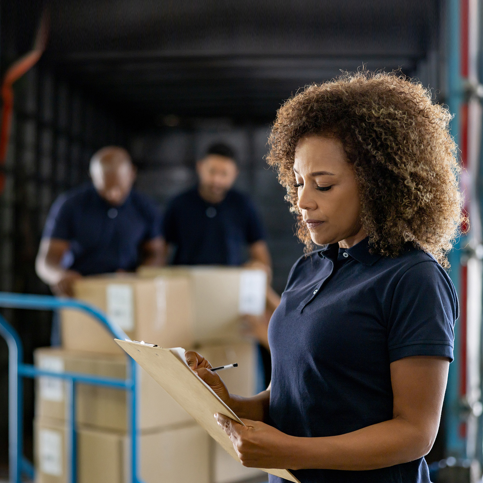 Woman supervising the shipping of cargo at a distribution warehouse stock photo