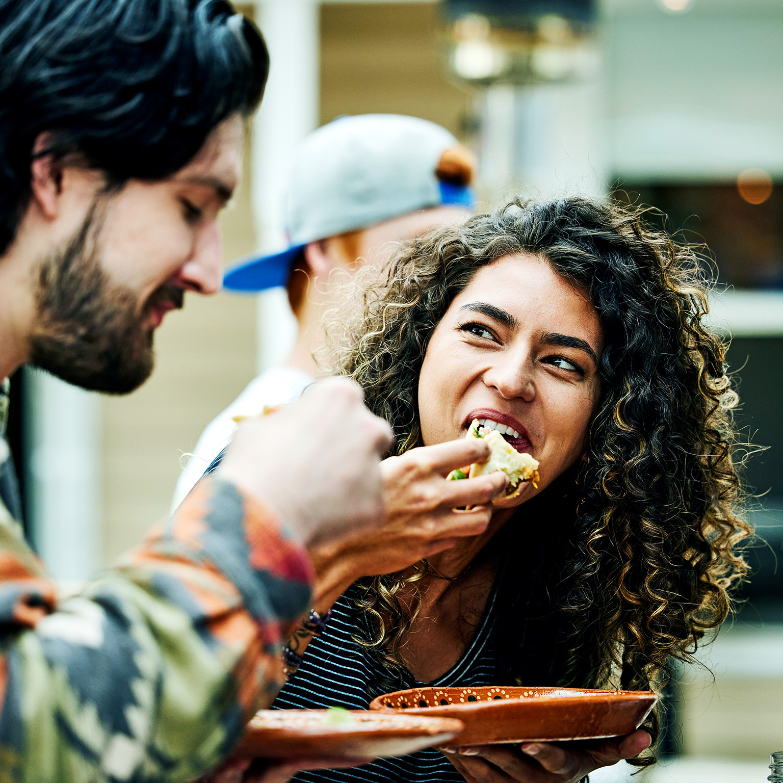 Medium close up shot of woman eating tacos with friends at food truck