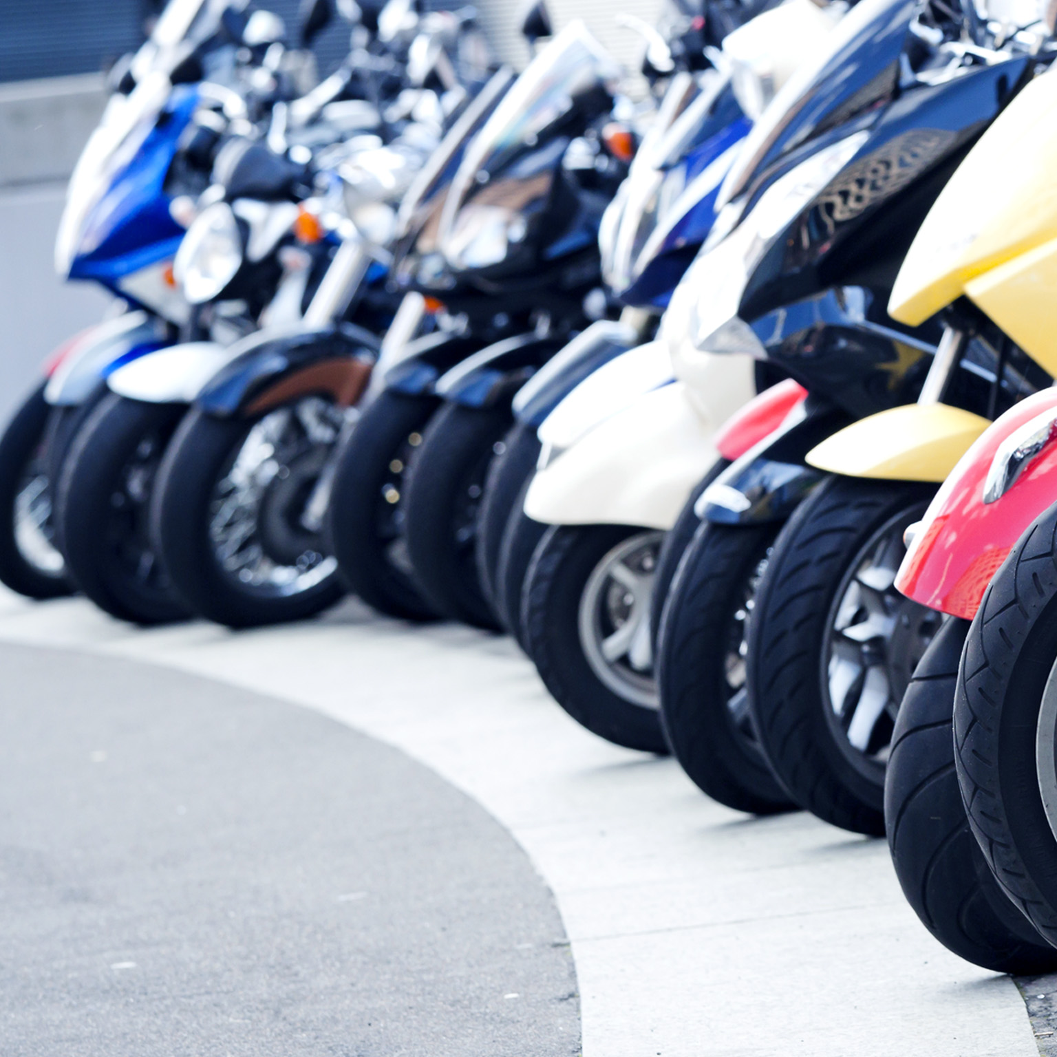 A row of motor scooters standing on the street