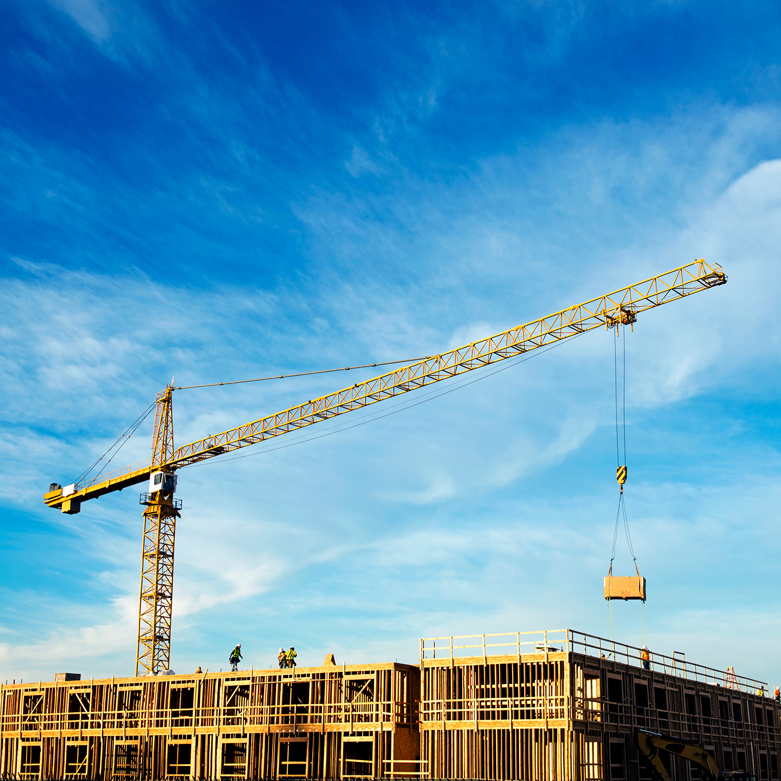 Crane at construction site against cloudy sky