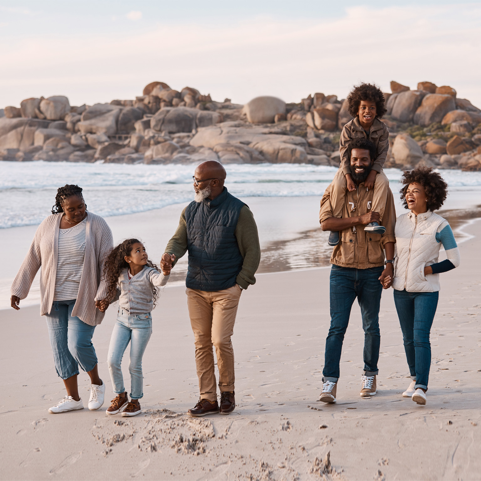 photo three generational family walking on beach