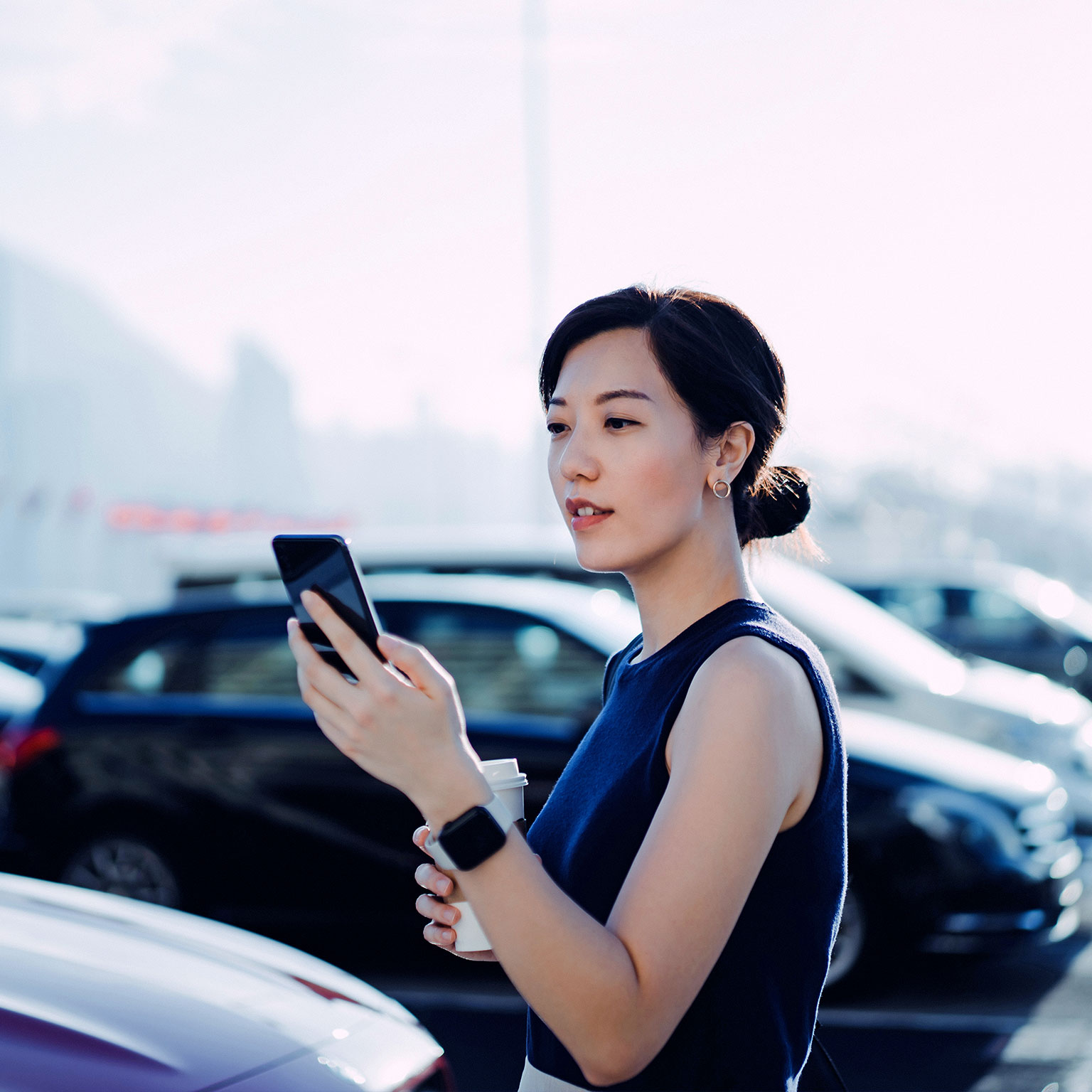 Woman in parking lot checking her phone