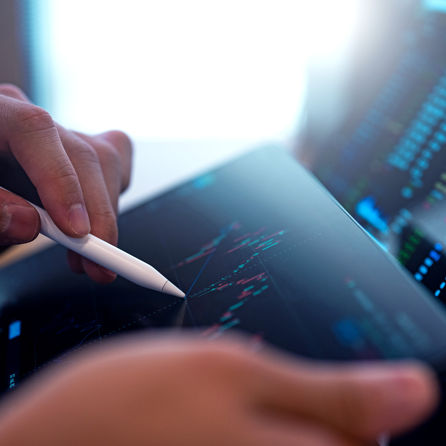 A business person tracking the technical movement of a stock chart on a computer screen.