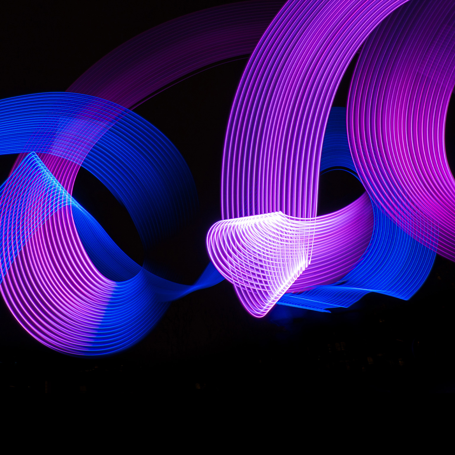 Conceptual blue and purple light lines painting swirling around and intersecting each other.