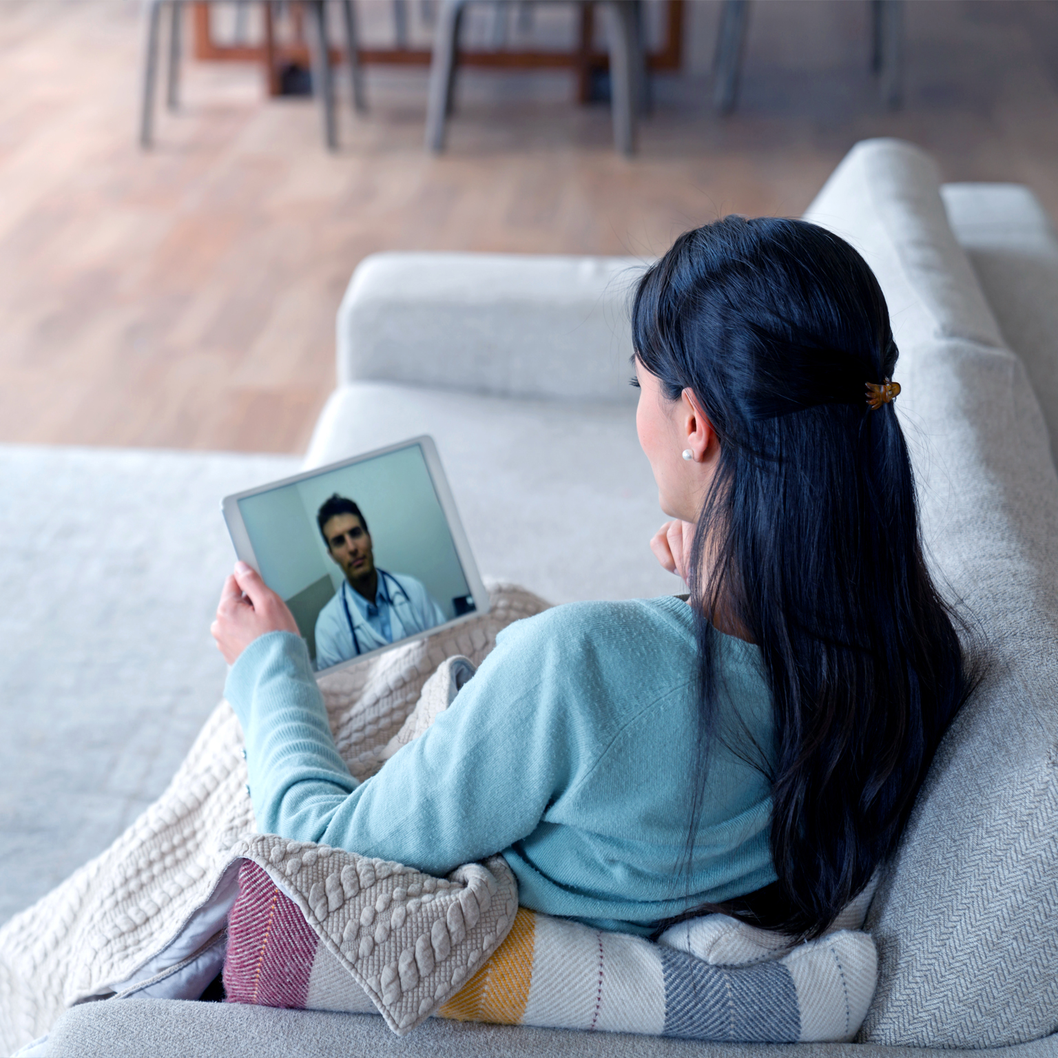 Woman at home feeling poorly and talking to her doctor on a video call