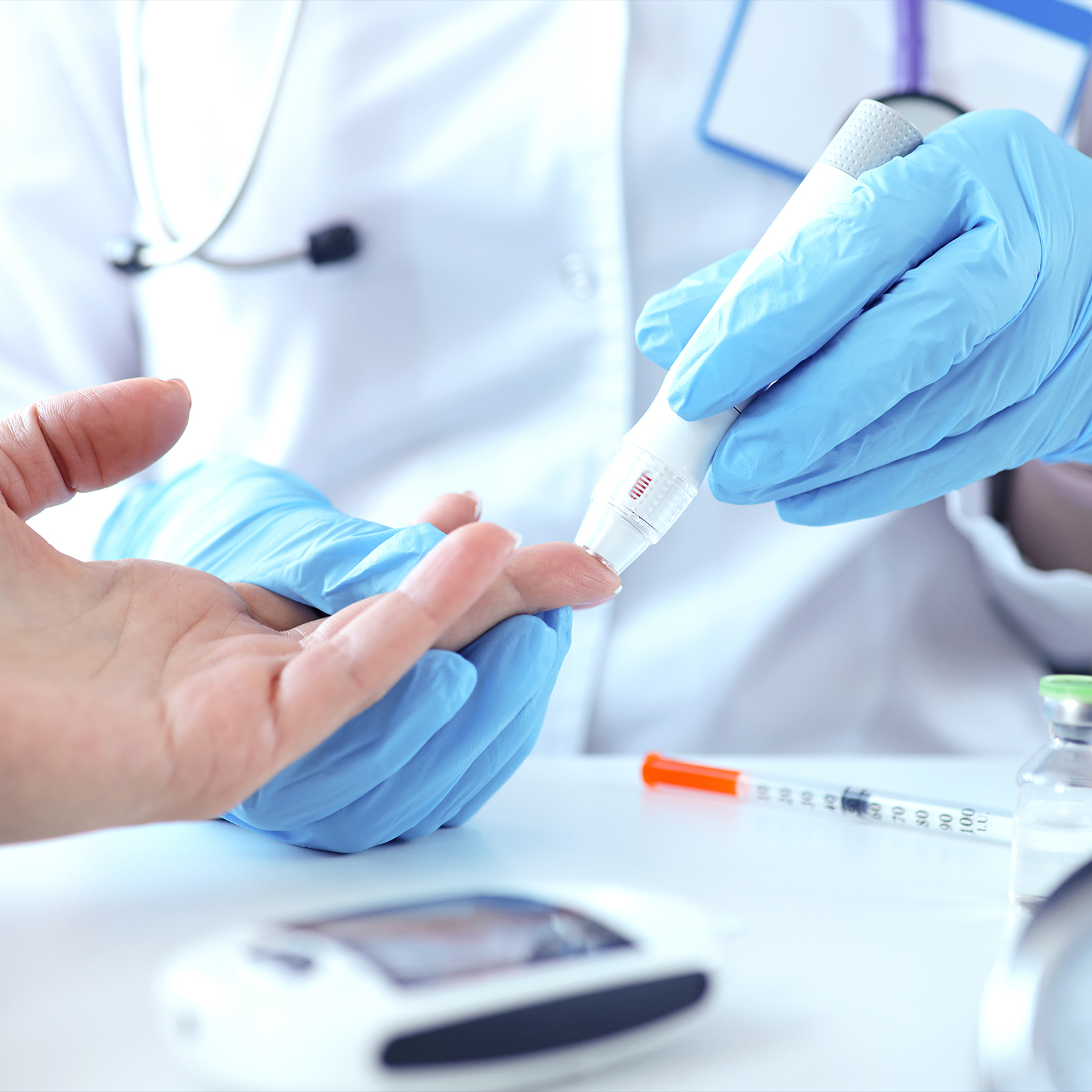 Doctor with gloves piercing patients finger with lancet closeup - stock photo
