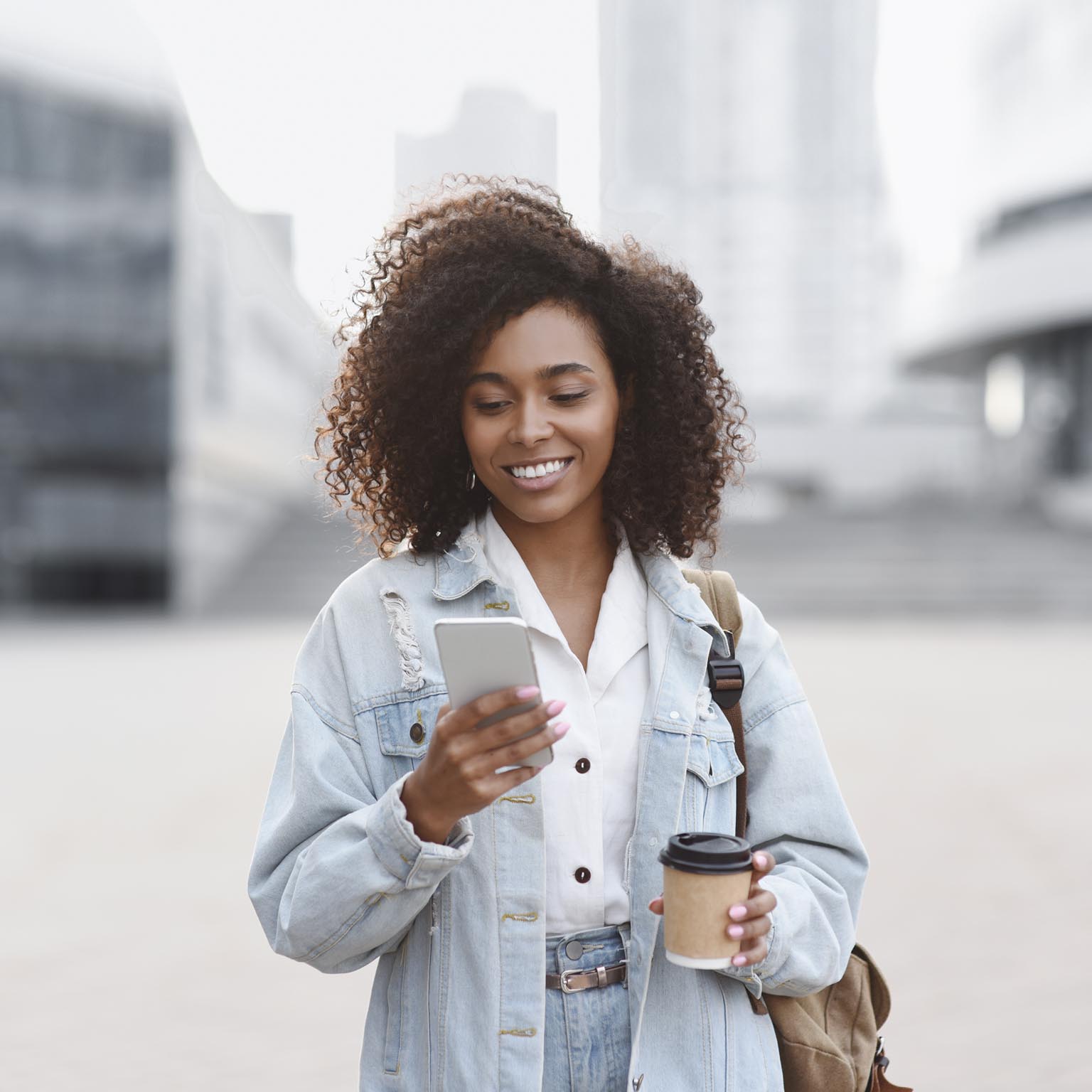 Young woman using smart phone on a city street