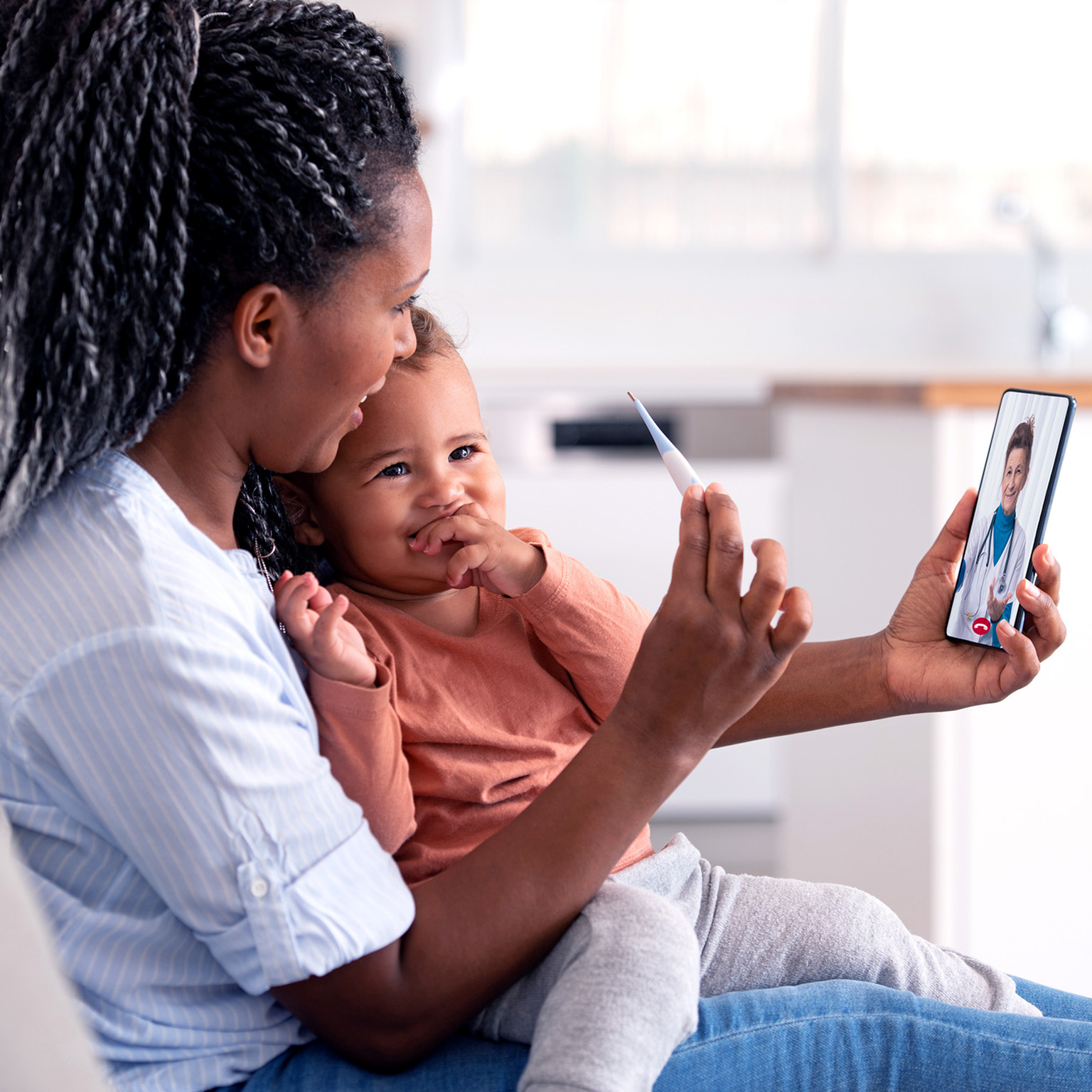 Woman and baby daughter using a smartphone to communicate with the doctor.