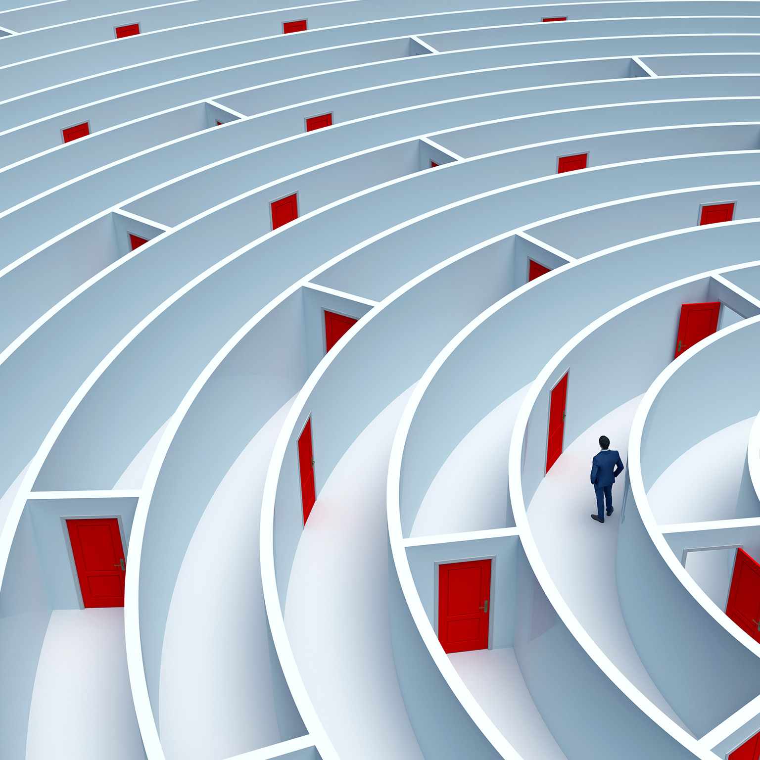 A man stands in the middle of a large maze that has many doors. A pathway out is not clear.