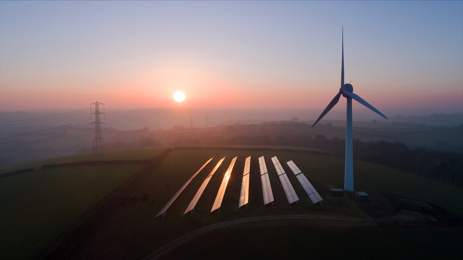 Solar panels and wind turbines in field - stock photo