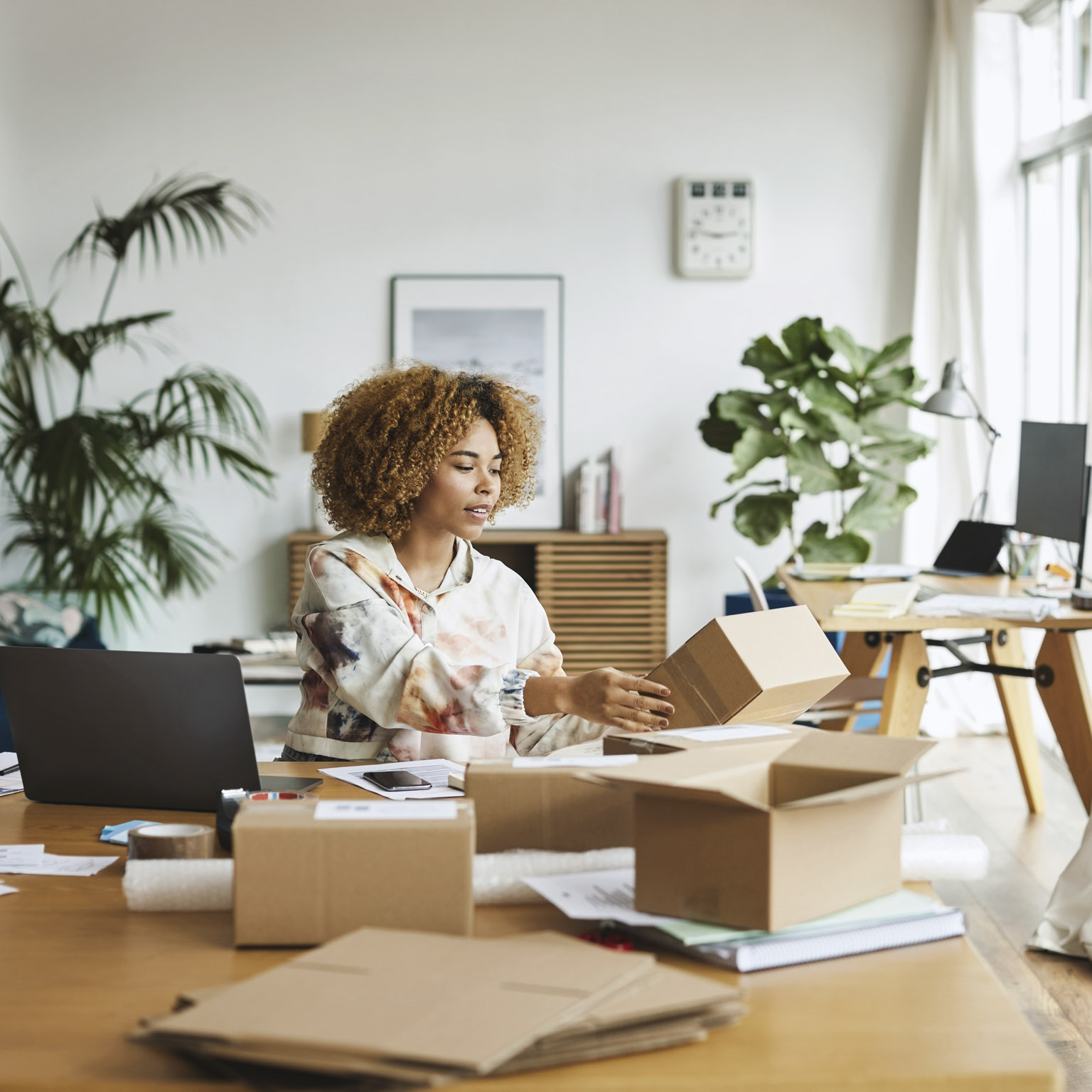 Female business professional analyzing packaging while sitting at table