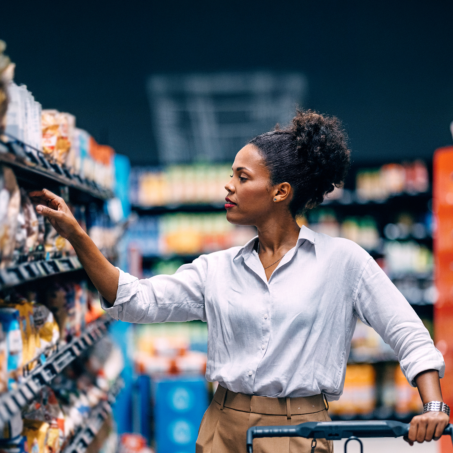 Woman Shopping in Supermarket Aisle Searching for Products