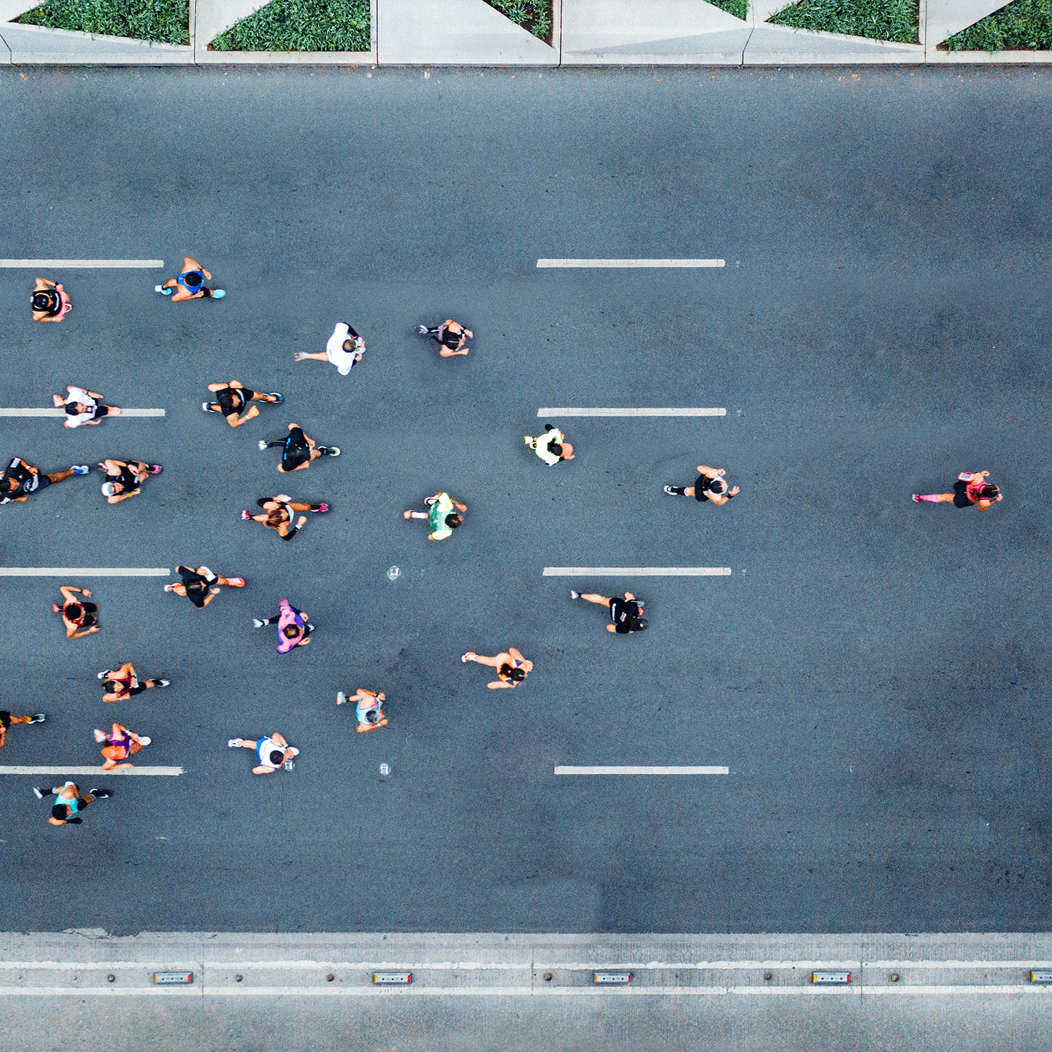  Aerial shot of marathon runners, with one runner leading the pack