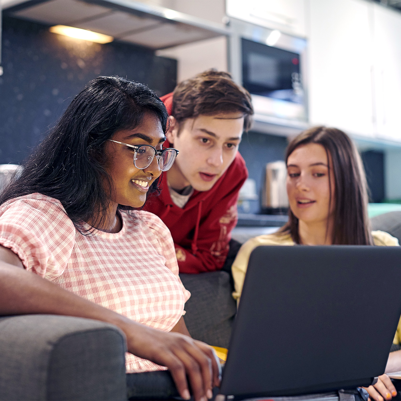 Friends hanging out together and chatting in university housing.