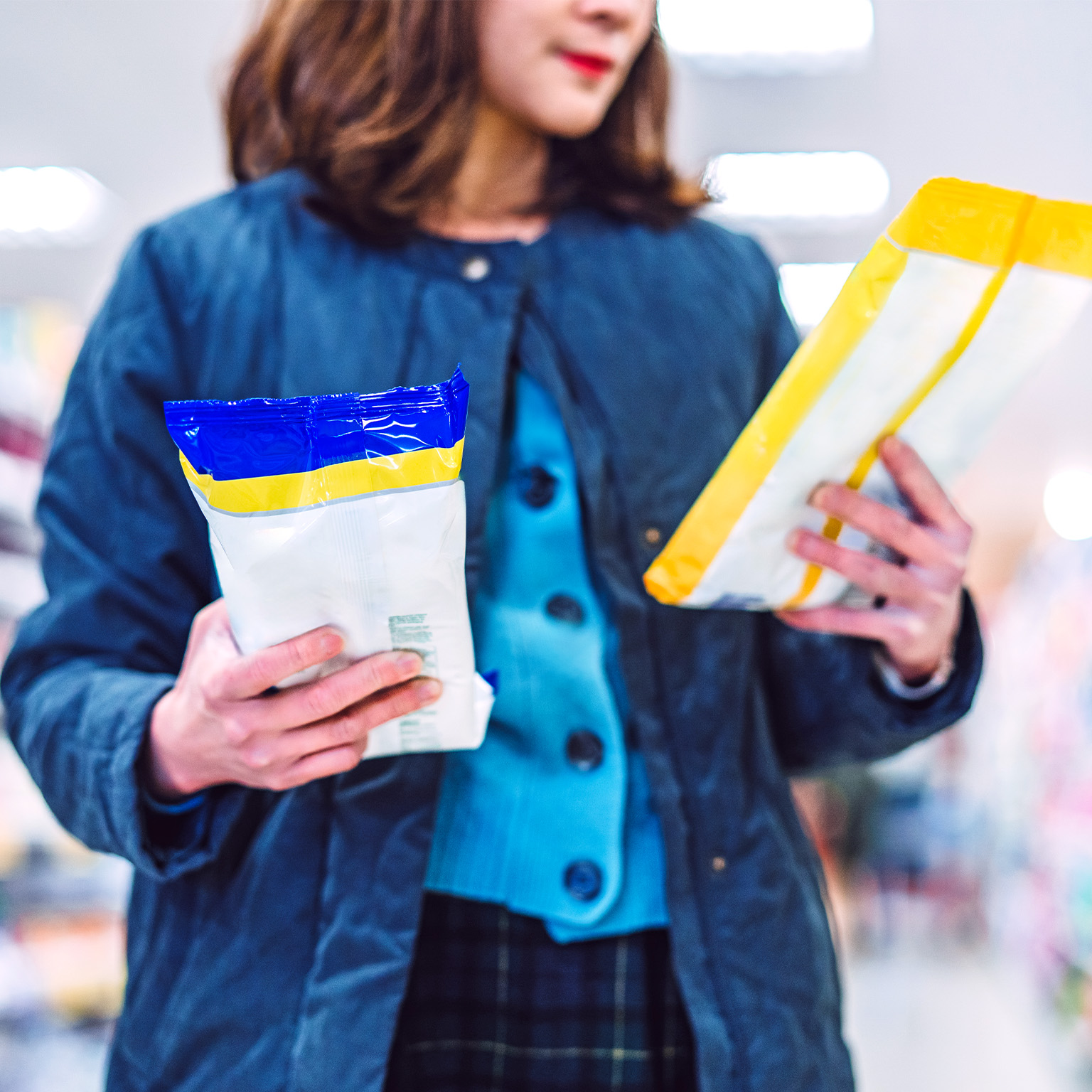 Image of a person reading the labels and comparing products in a store.