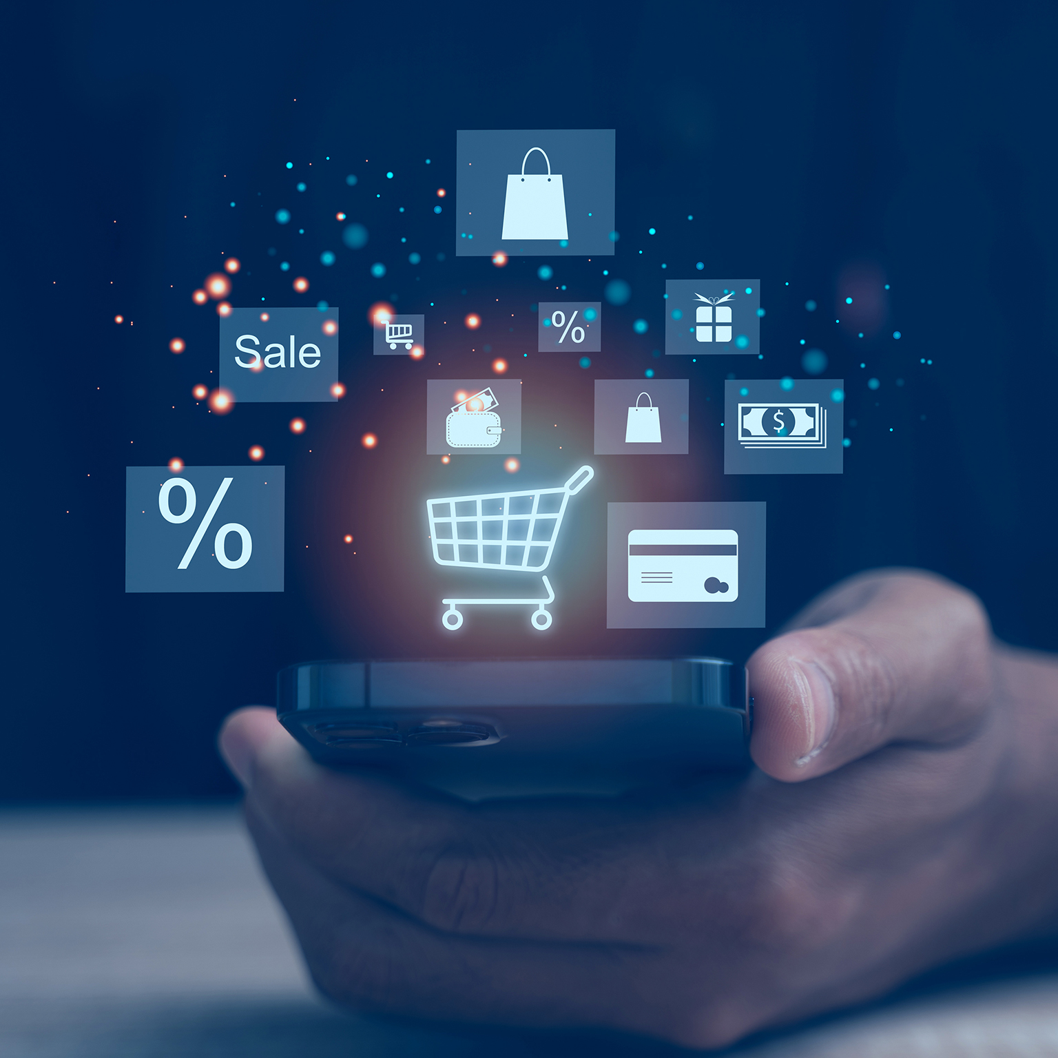 Hand holding a smartphone displaying floating shopping and payment icons, including a cart, discount symbol, and credit card.