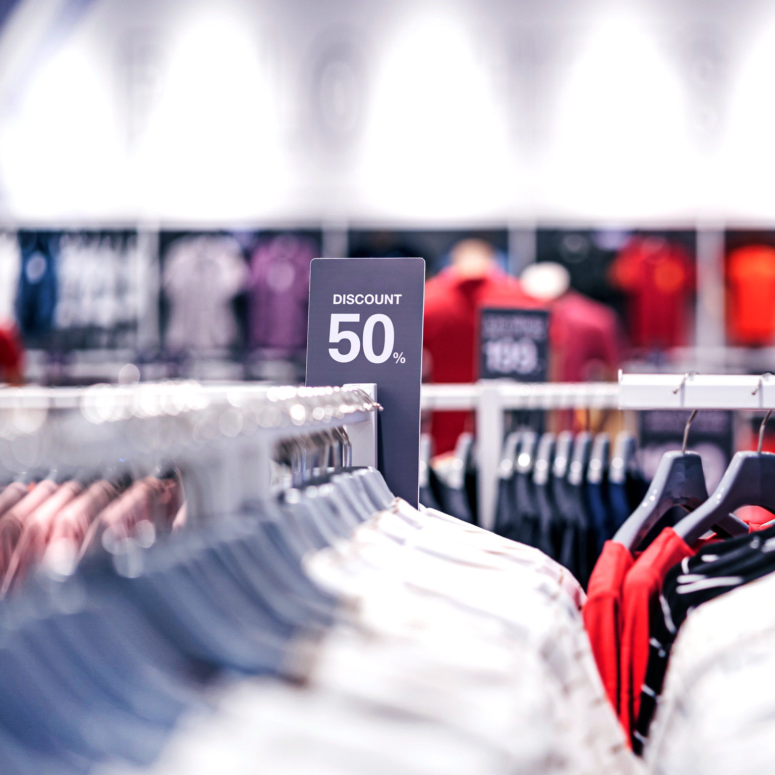Discount 50% label of sales tag price over the clothes line in a shopping department store.