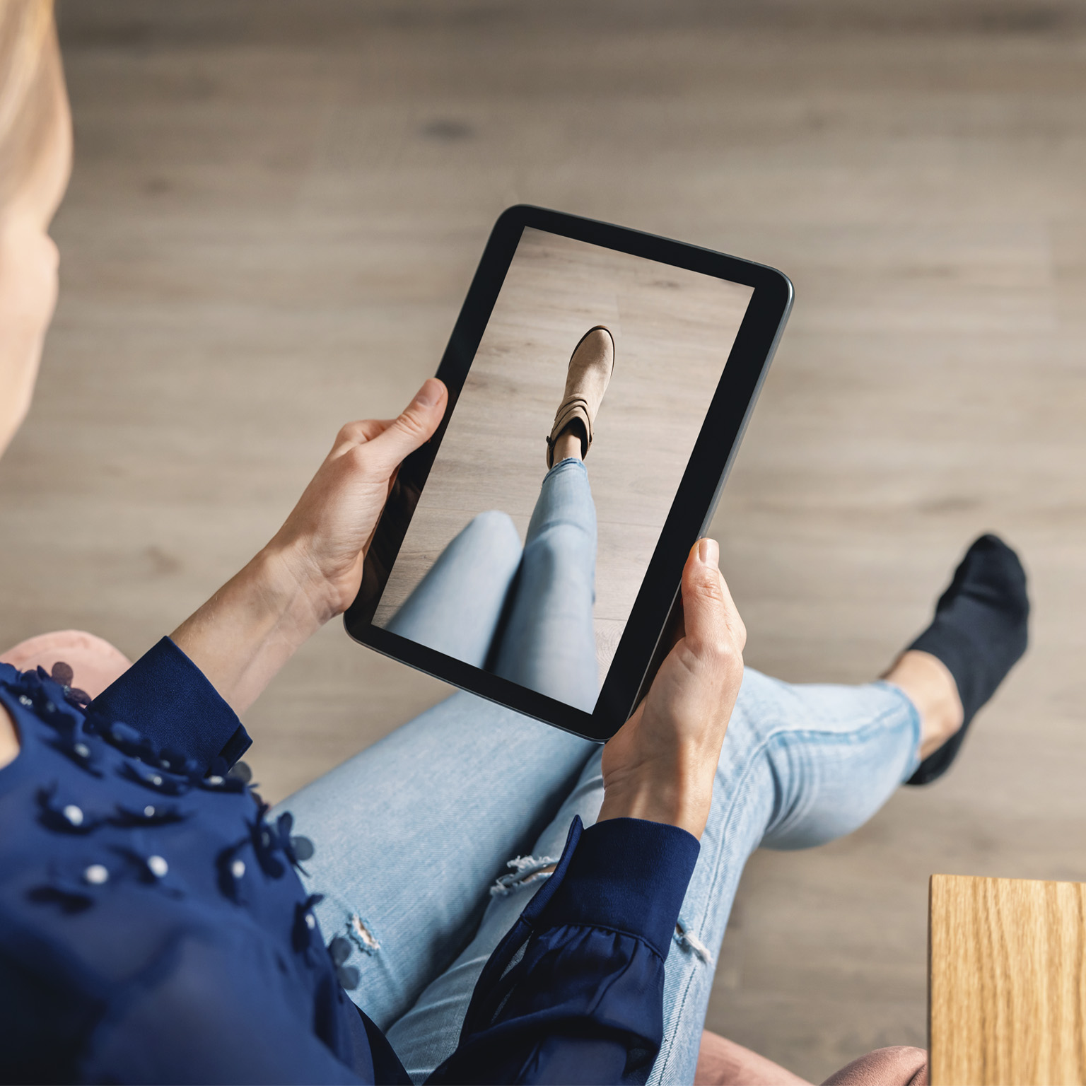 Woman trying on shoes online with digital tablet