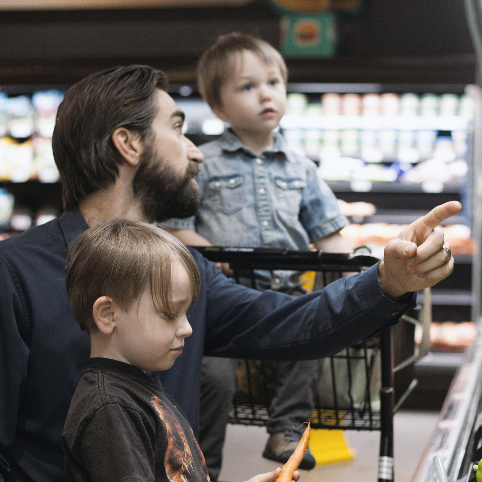 Father grocery shopping with his two children