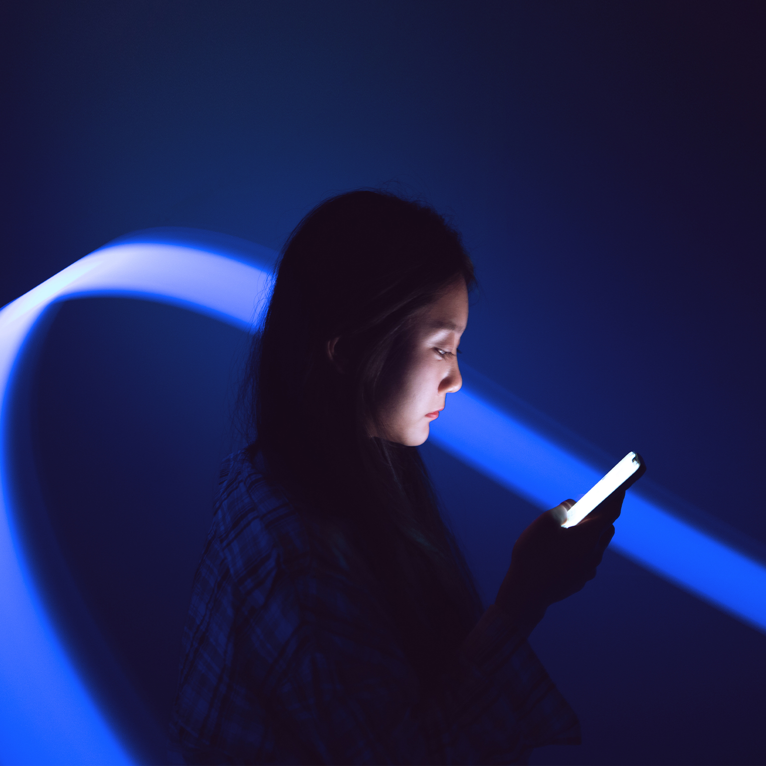Young Asian woman using smartphone on the holographic background. Metaverse and AI - stock photo