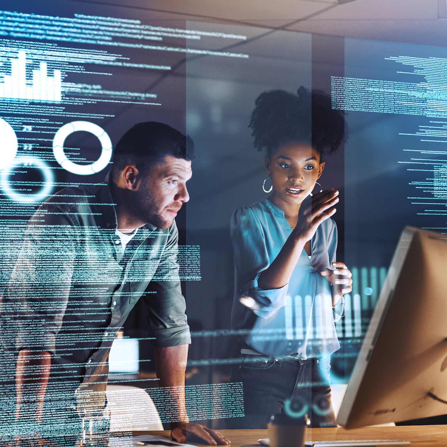 Shot of two programmers working together on a computer code at night - stock photo