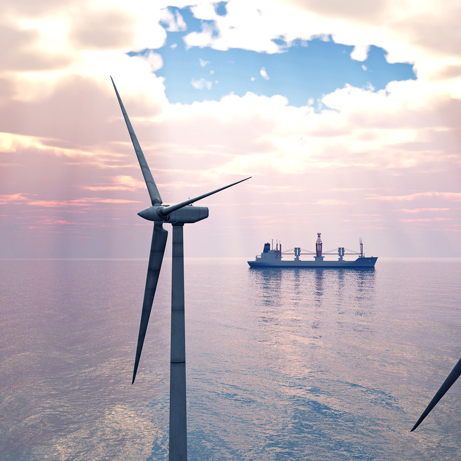 Close-up of offshore wind turbines with a cargo ship in the distance