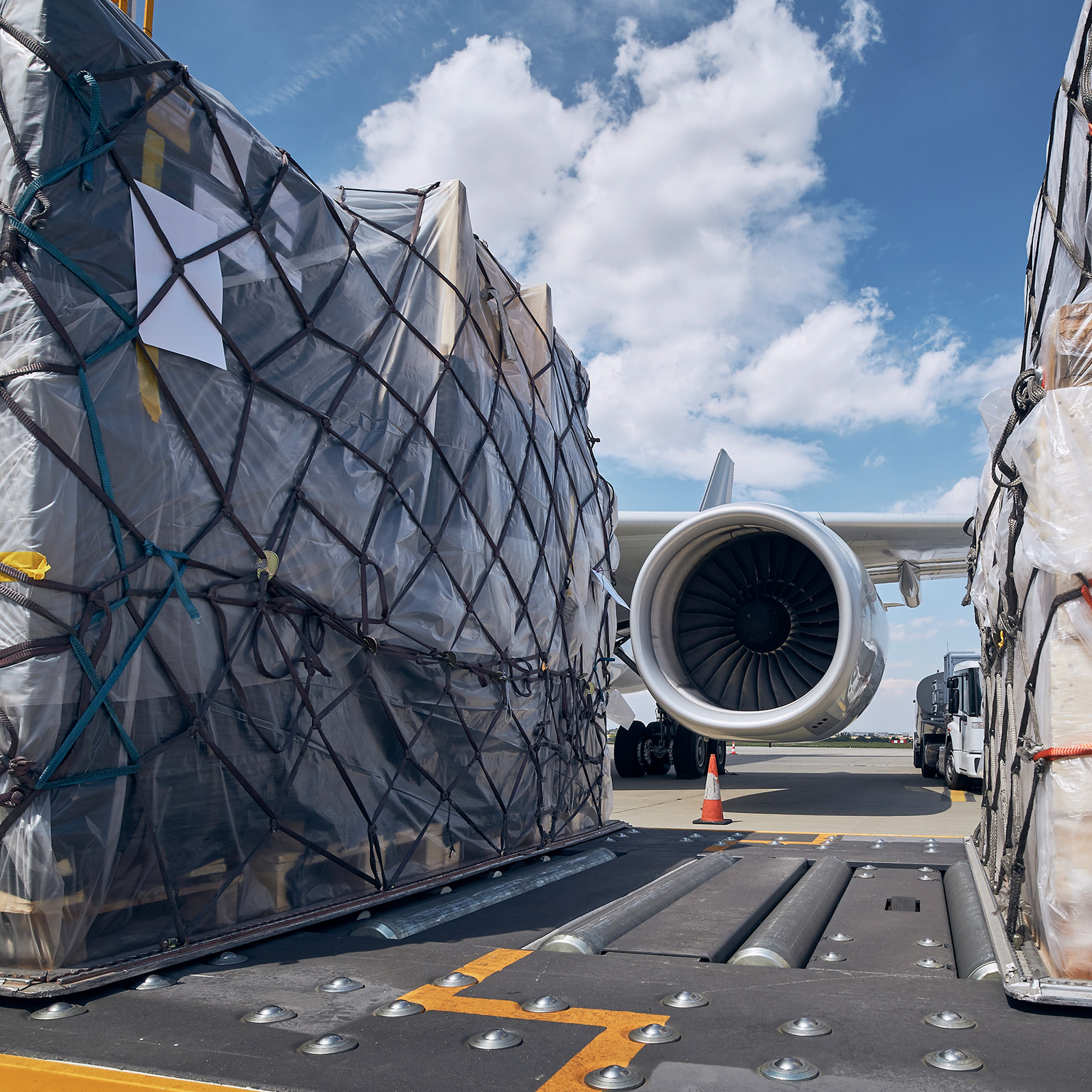 Preparation Before Flight. Loading Of Cargo Containers Against Jet Engine Of Freight Airplane.