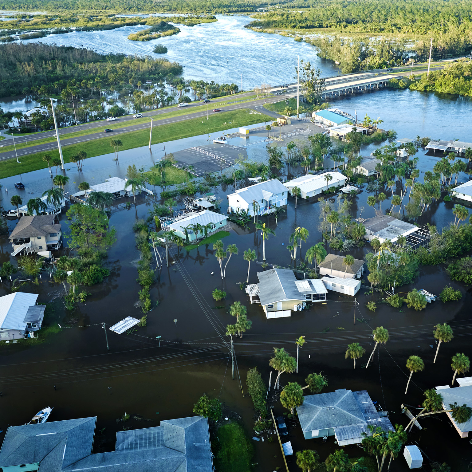 An aerial perspective of a heavily flooded Florida neighborhood next to a river after Hurricane Ian.