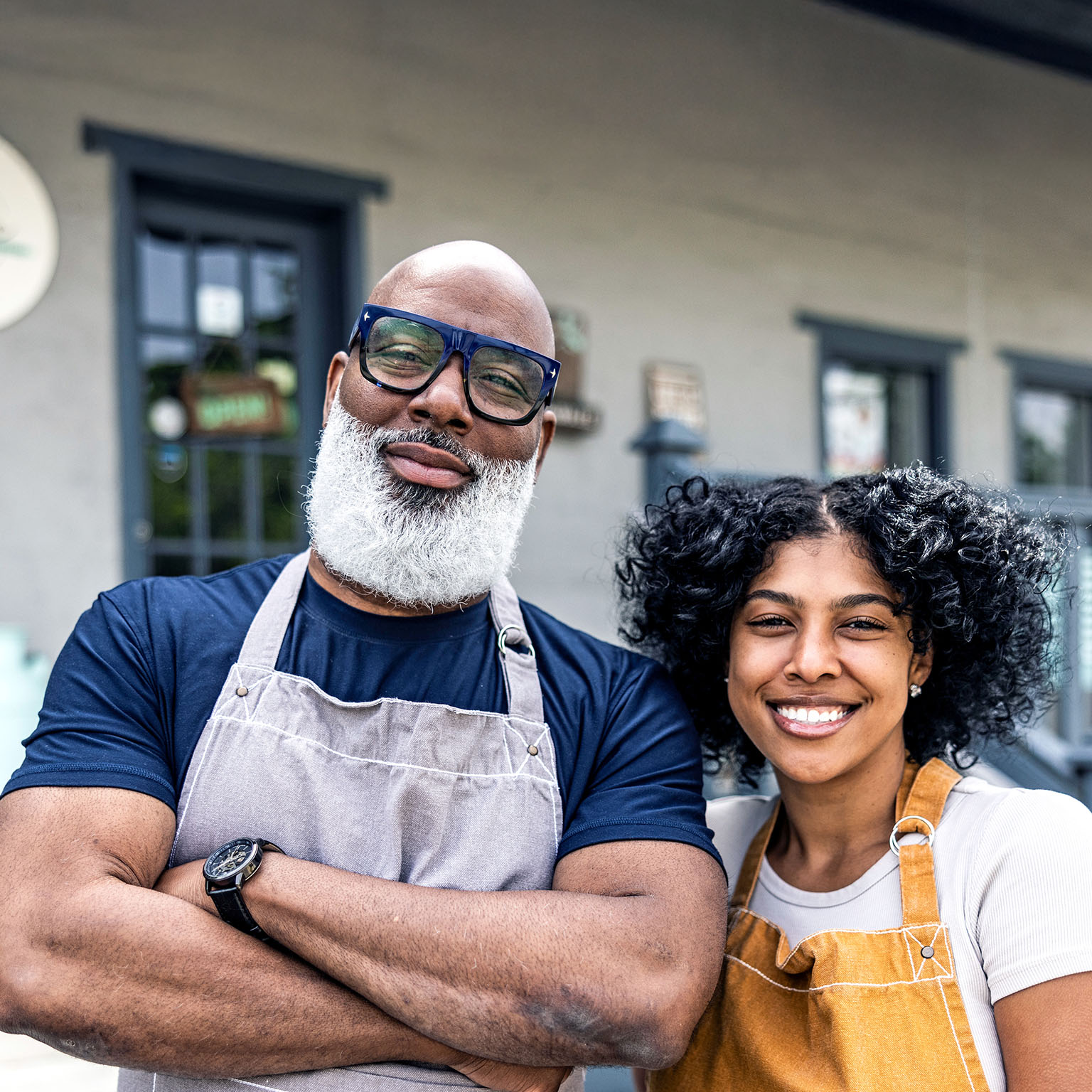 Portrait of father and daughter small business owners in front of family business