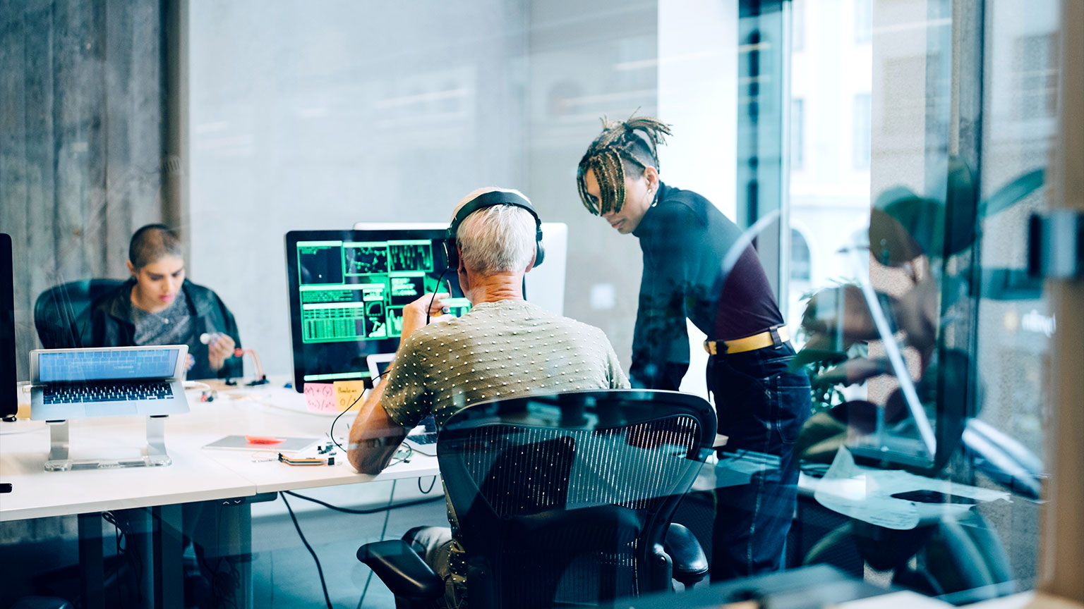 Two people working on code in a modern office.
