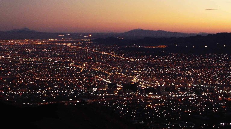 City illuminated at dusk showing electrical power grid distribution