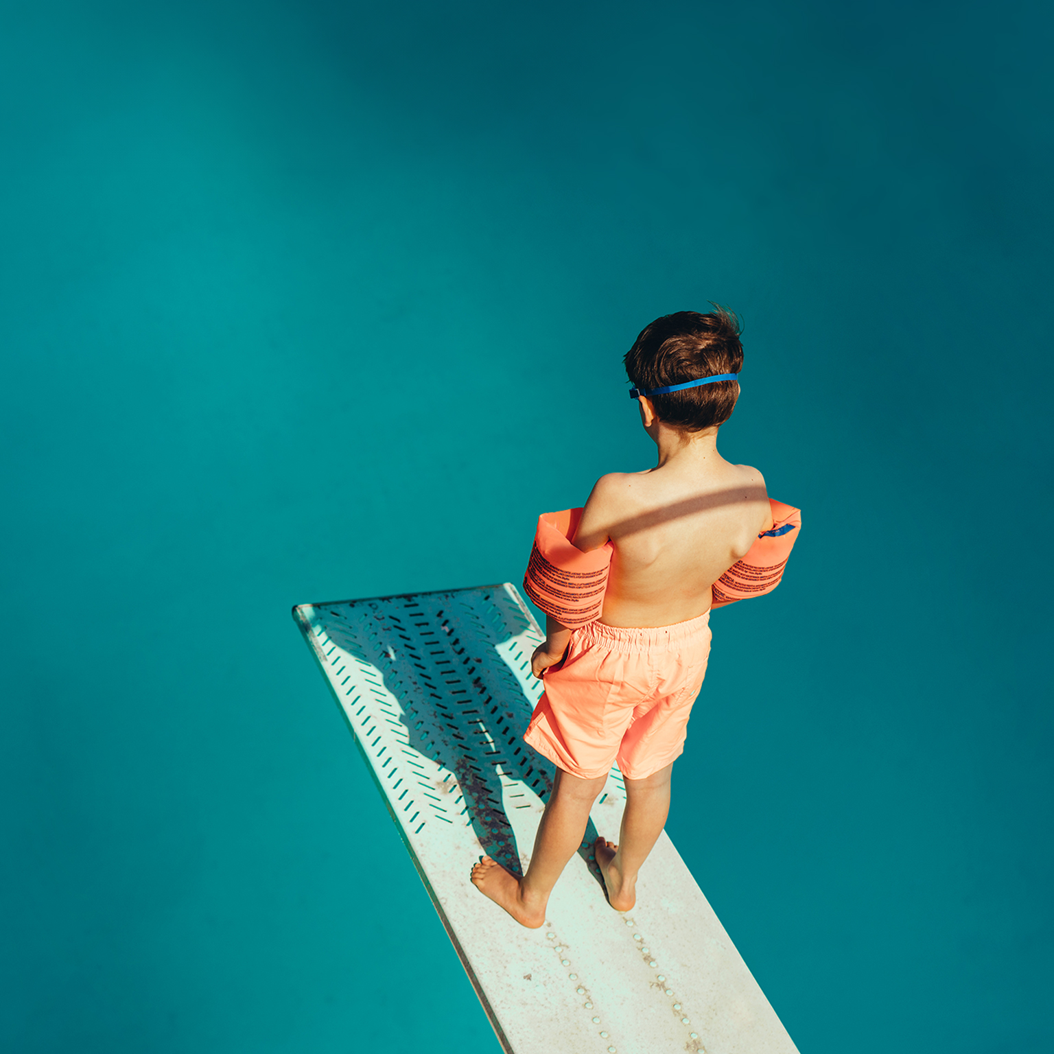 Boy standing on a diving board - stock photo