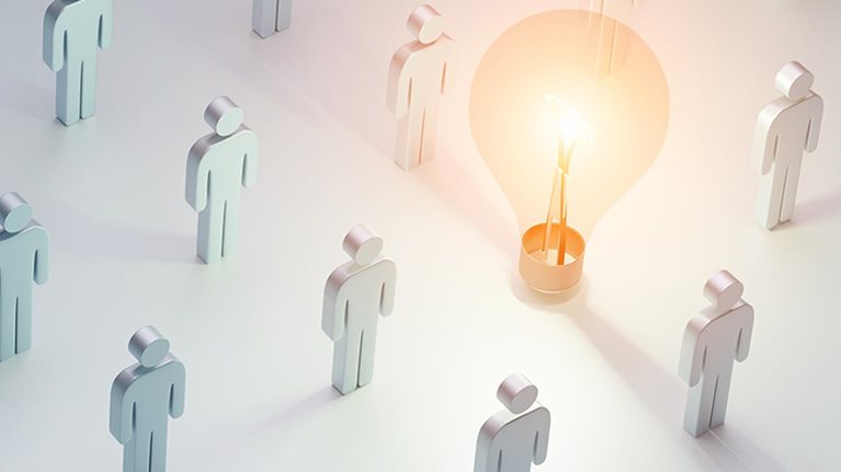 Concept of ideas. Masses of icon people standing around light bulb glowing brightly.